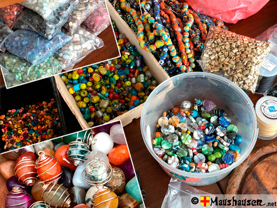 Bild mit verschiedenen Glasperlen, welche zu Ketten verarbeitet wurden.