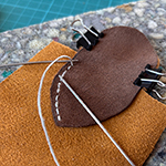 Von der Idee zum Lederbeutel, Schnittmuster erstellen, Leder zuschneiden und vernähen bis ein fertiges Retikül entstanden ist.